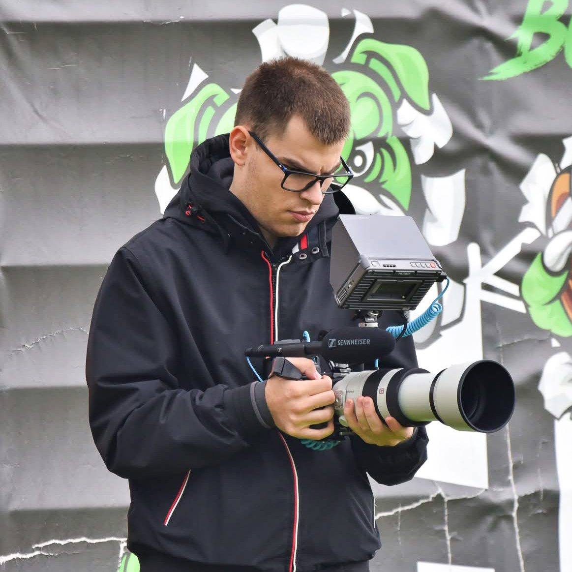 Leon Frick Medienproduktion mit einer Kamera in der Hand bei einem DFB Pokal Spiel